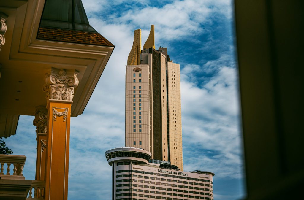 Stunning view of the Millennium Hilton tower in Bangkok with vibrant cloudy skies.
